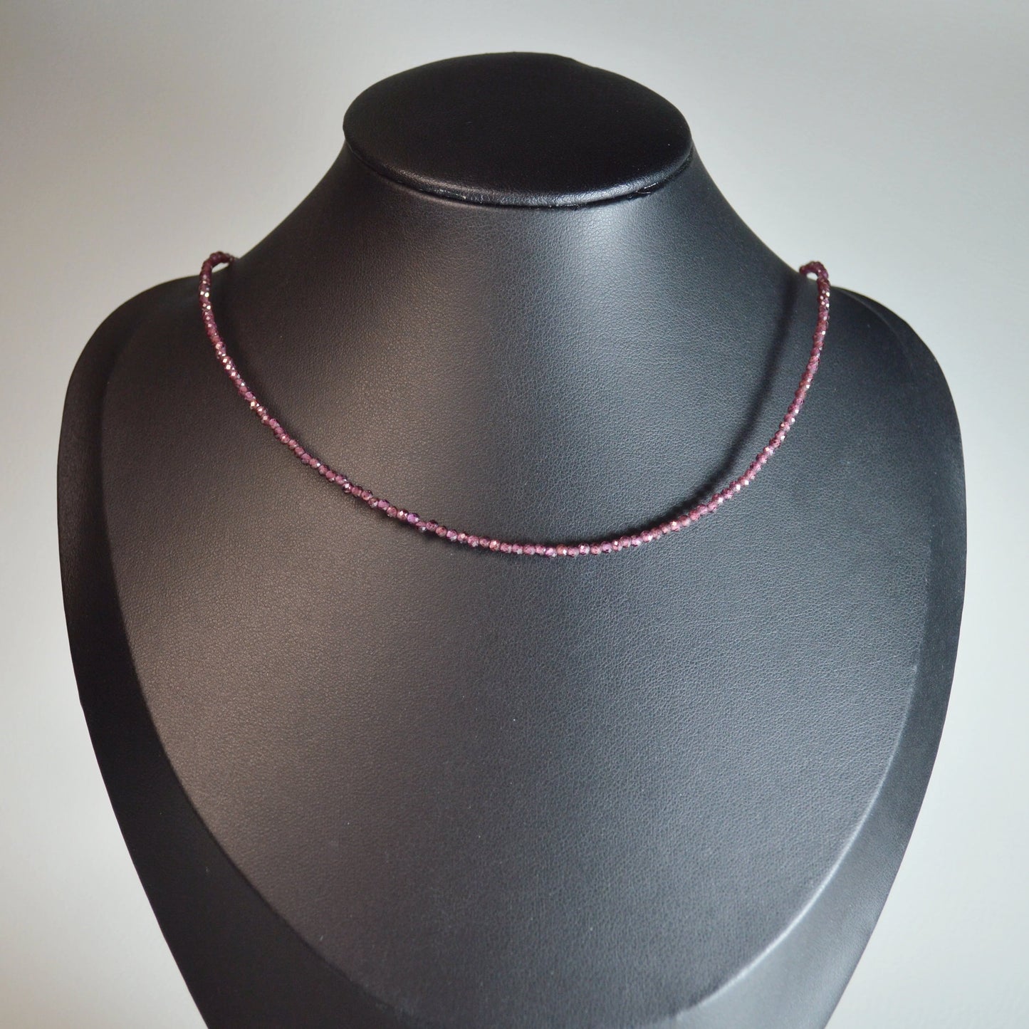 Almandin Granat Perlenkette aus 2mm Naturstein – Kristallschmuck mit Metallverschluss auf Büste.