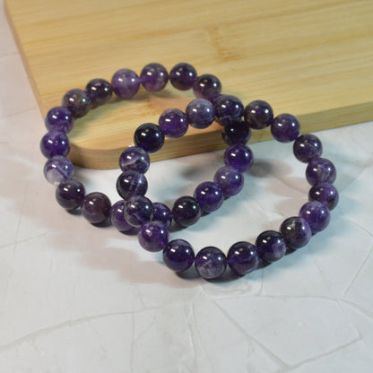 Amethyst Armband aus Brasilien mit 10mm Perlen, zwei elastische Armbänder um naturbedingte Unterschiede zu zeigen.