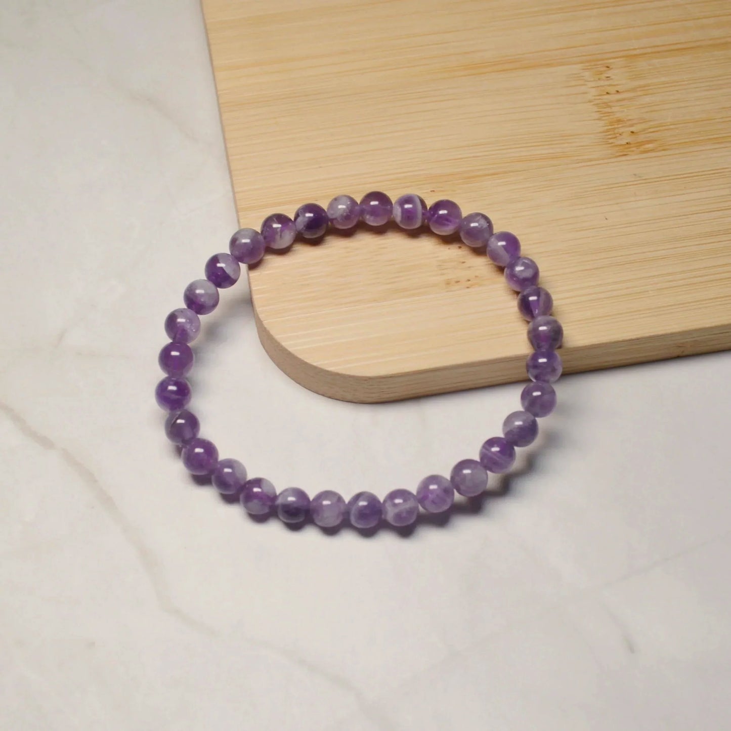 Amethyst Armband mit hochwertigen 6mm Perlen, handgefertigt und naturbelassen - Einzelansicht.