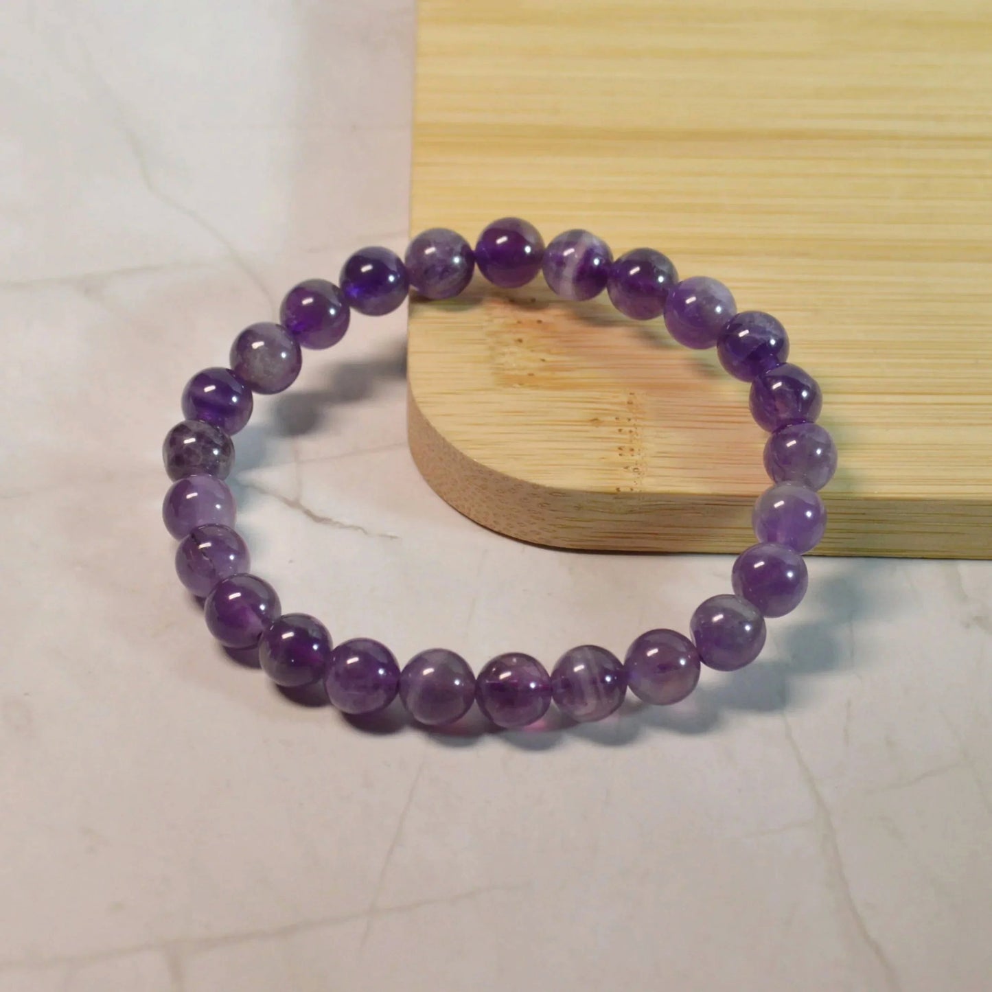 Amethyst Armband mit hochwertigen 8mm Perlen, handgefertigt und naturbelassen - Einzelansicht.