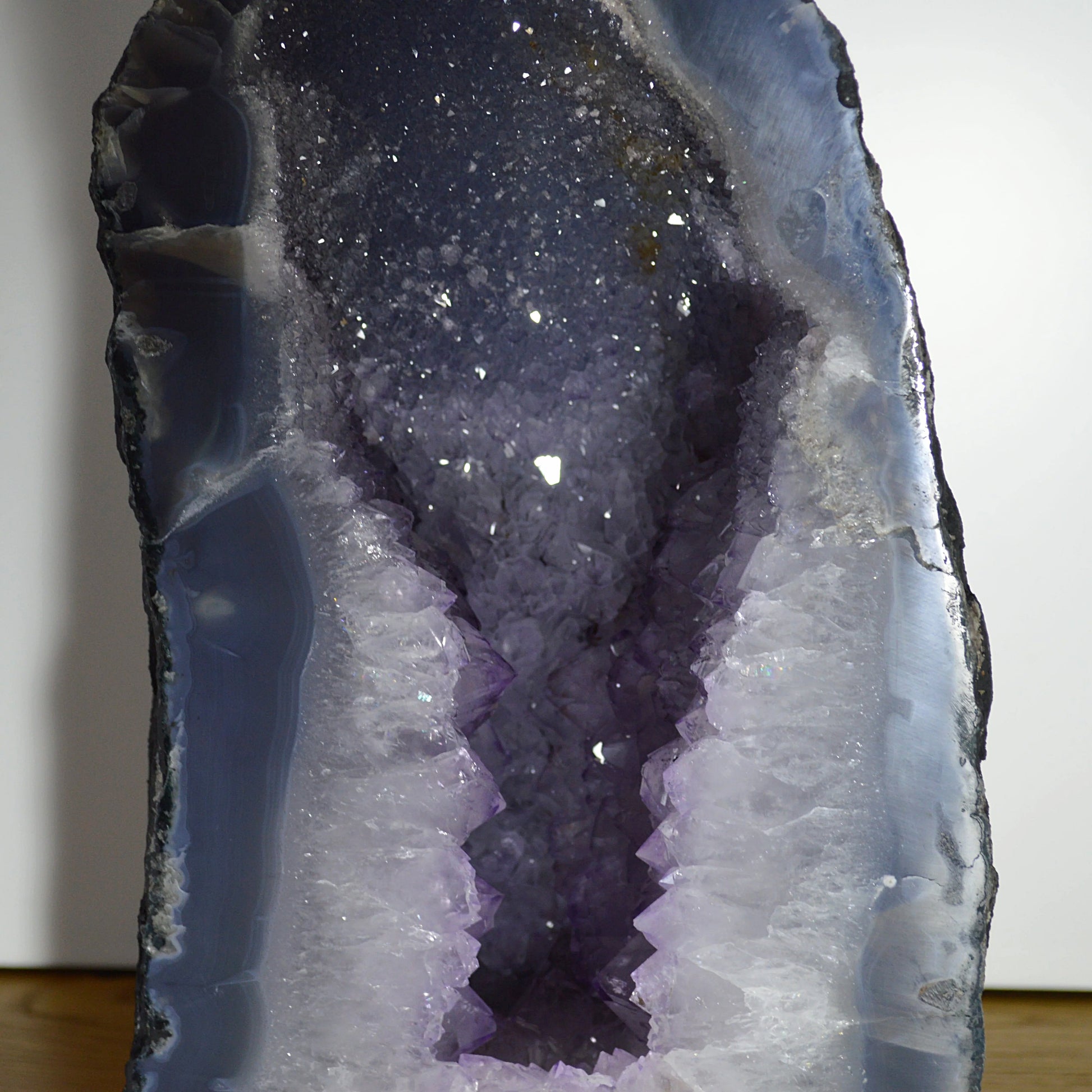 Detailaufnahme der Amethyst-Kristalle in der Druse mit Achat-Rand von Natural Crystals – Naturstein-Unikat.