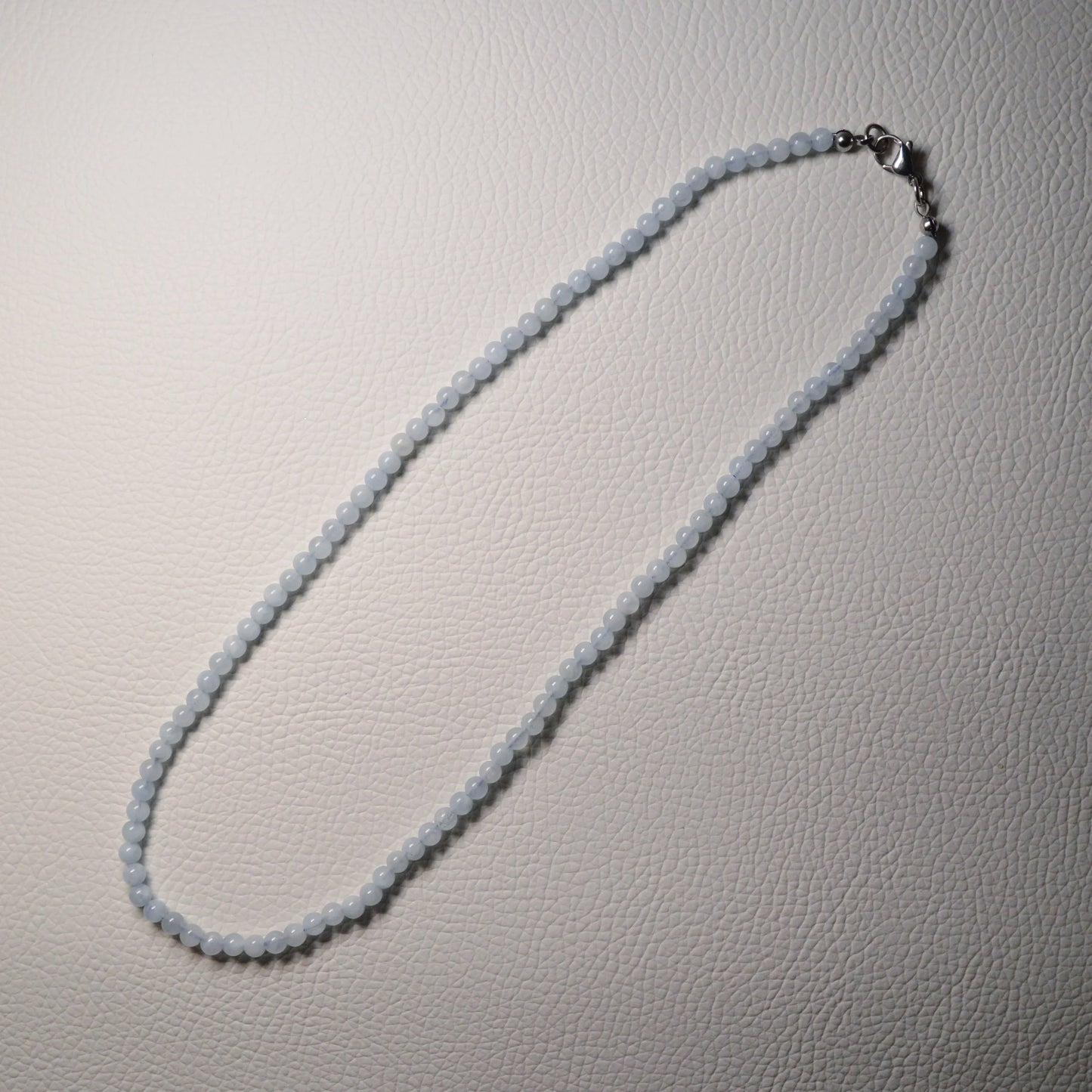 Aquamarin Perlenkette aus 4mm Naturstein – Kristallschmuck mit Metallverschluss. Gesamtansicht.