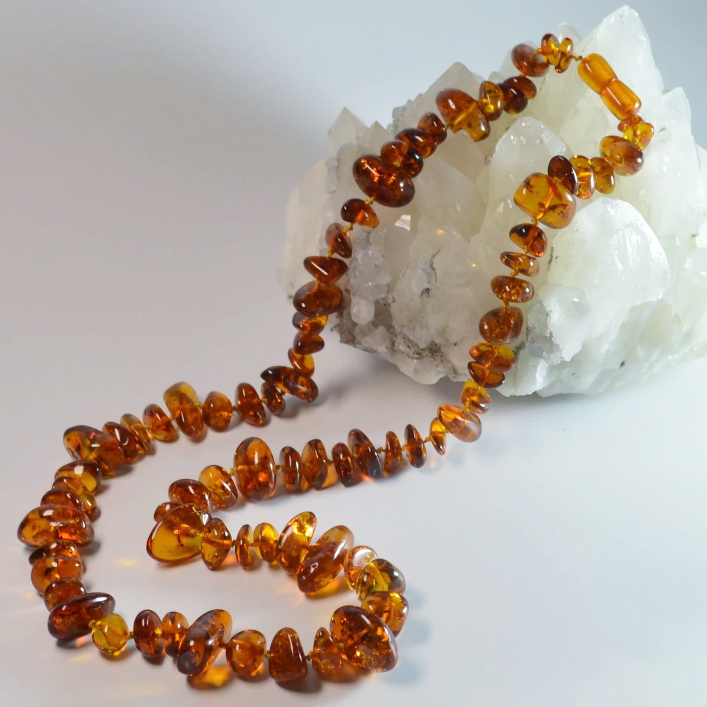 Baltische Bernstein Kette 70 cm – Gesamtansicht liegend, natürlicher Glanz der Steine und Drehverschluss erkennbar.