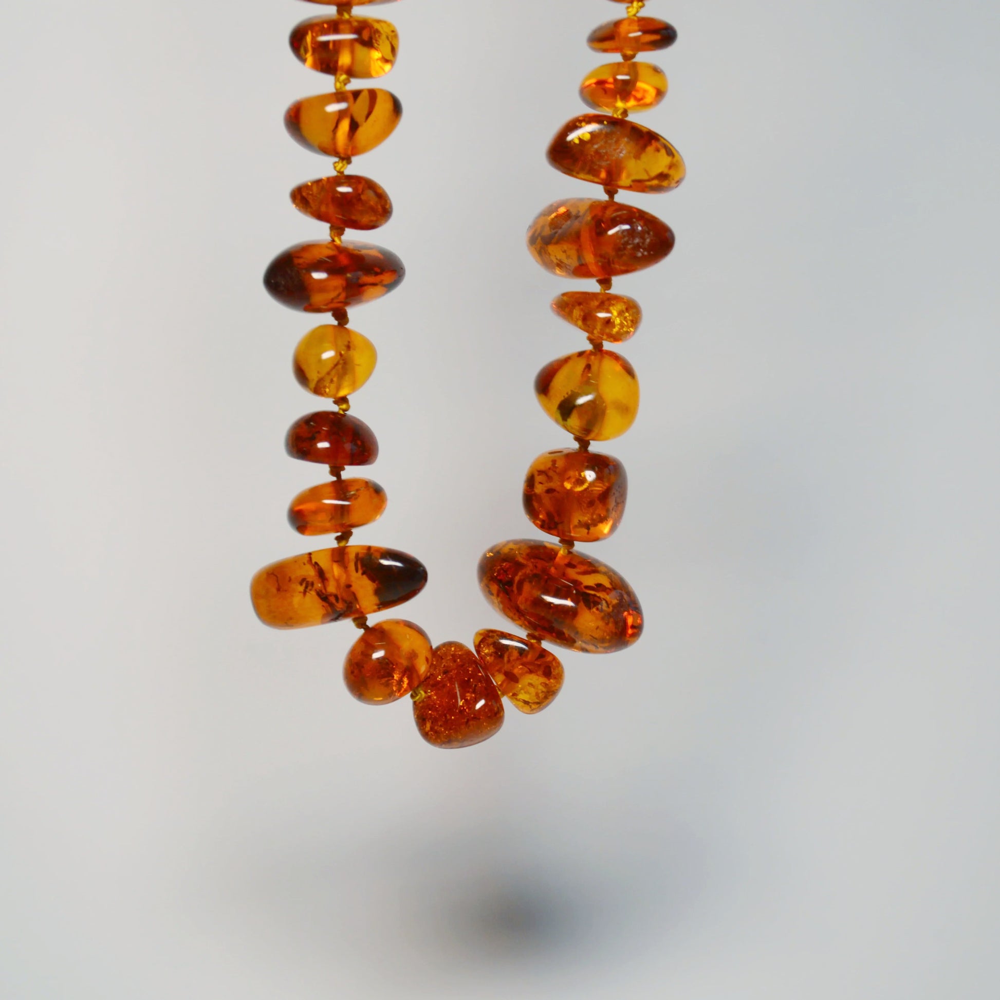 Baltische Bernstein Kette 70 cm – Nahaufnahme hängend, Details der Steine und Farben deutlich sichtbar.