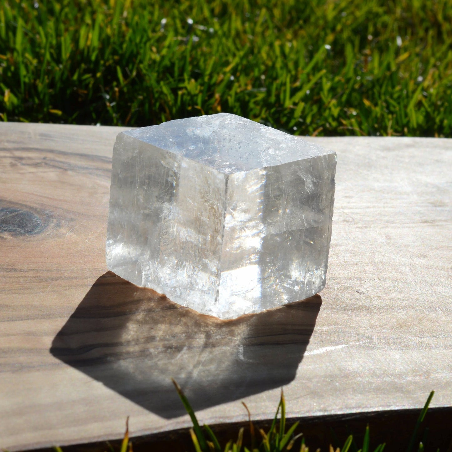 Calcit-Doppelspat-Kristall mit natürlichen Einschlüssen, fotografiert im Sonnenlicht zur Darstellung der Lichtbrechung