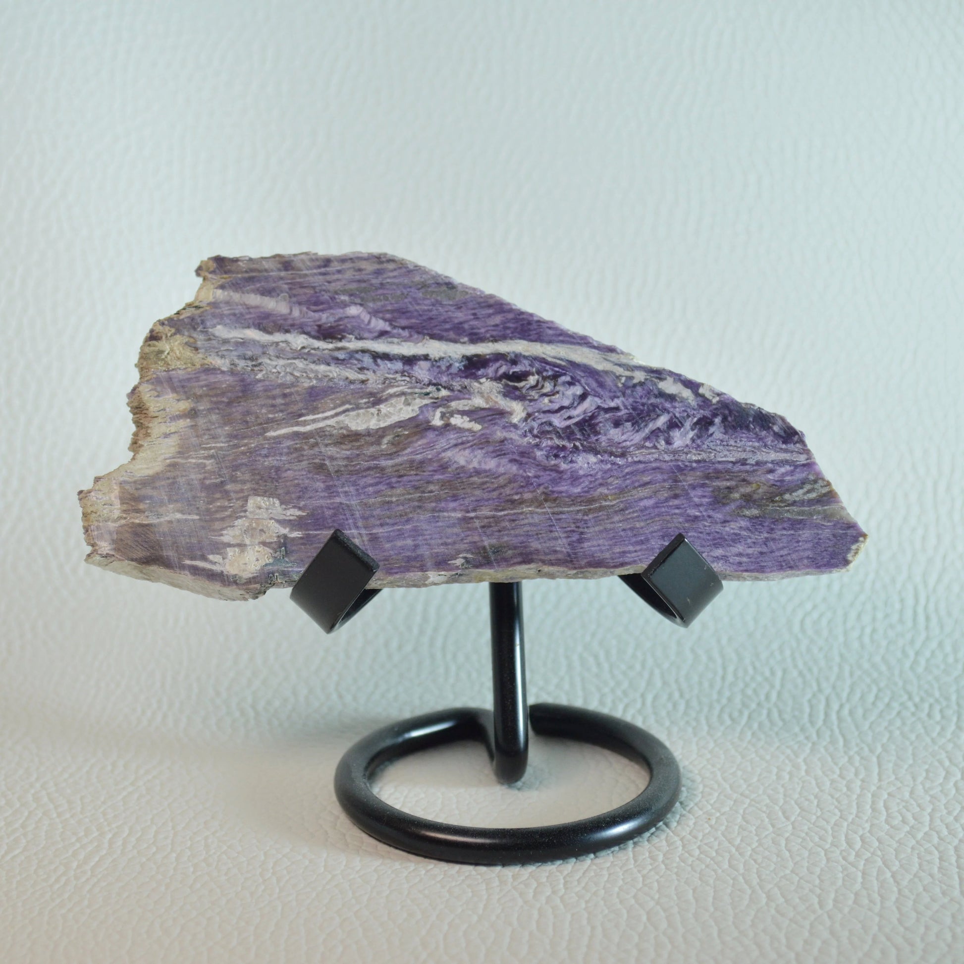 Violette Charoit Natursteinplatte auf Halterung, handgeschliffen. Rückseite.