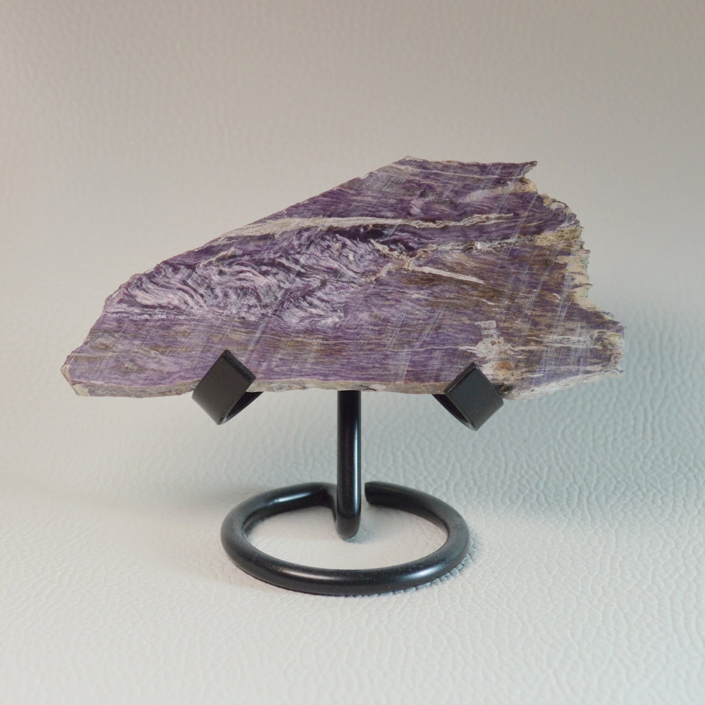 Charoit Platte auf Halterung, violette Natursteinstruktur, echtes Einzelstück. Vorderansicht.