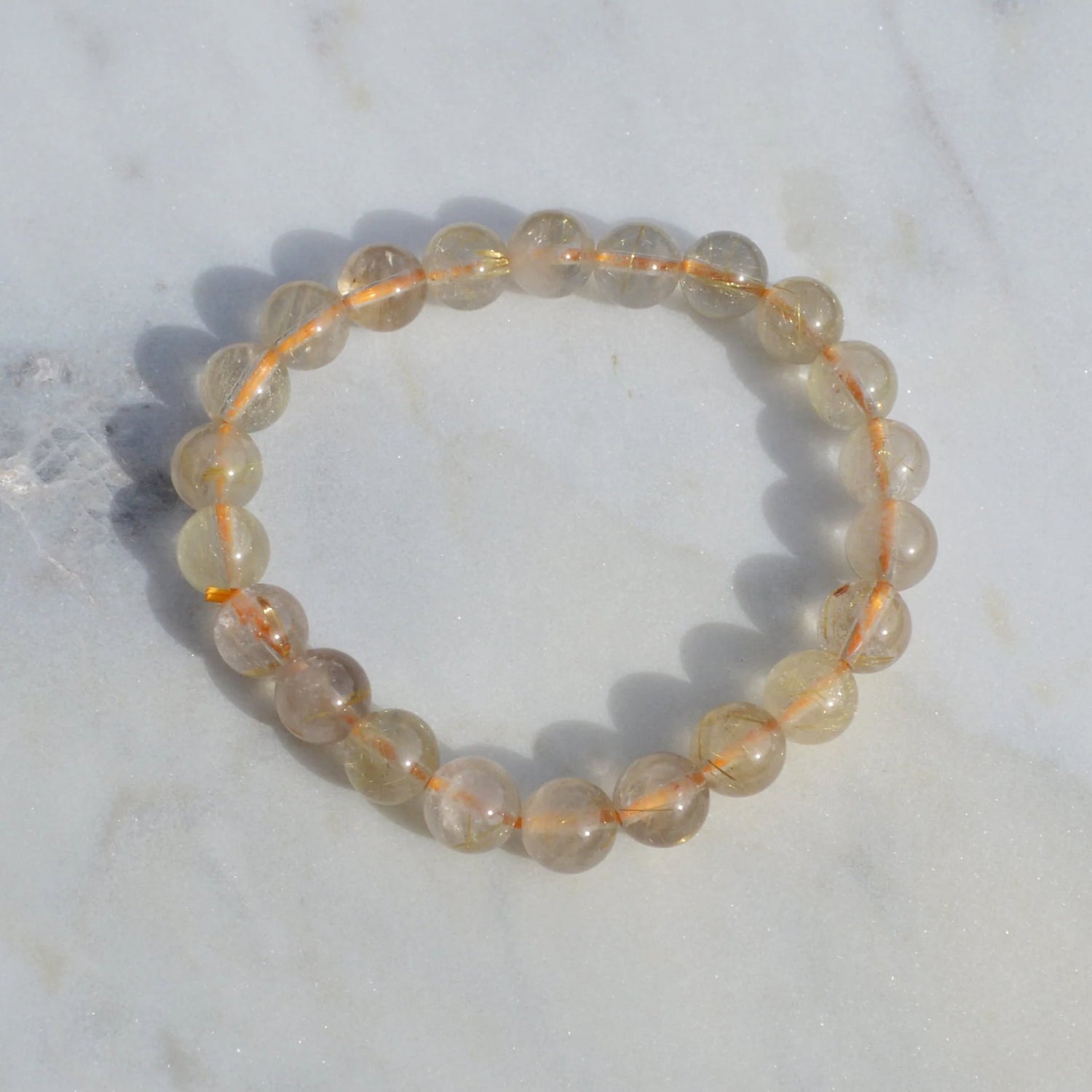 Gold Rutilquarz Armband mit hochwertigen 8mm Perlen, handgefertigt und naturbelassen - Einzelansicht.