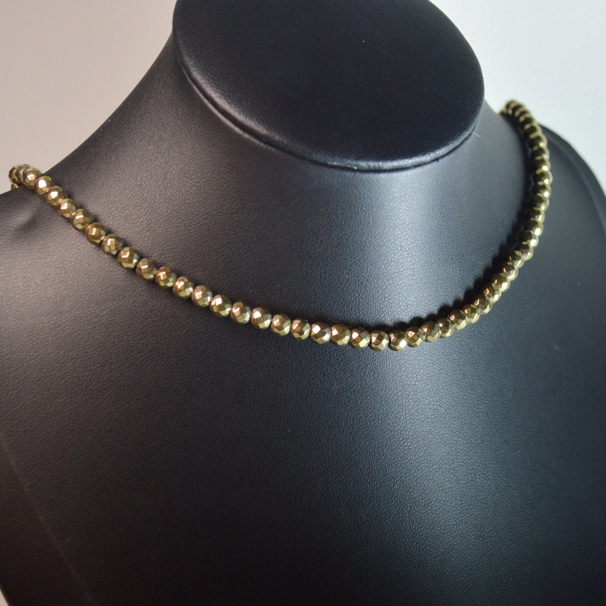 Goldene Hämatin 4mm Perlenkette  – Stein Schmuck mit Metallverschluss auf Büste.