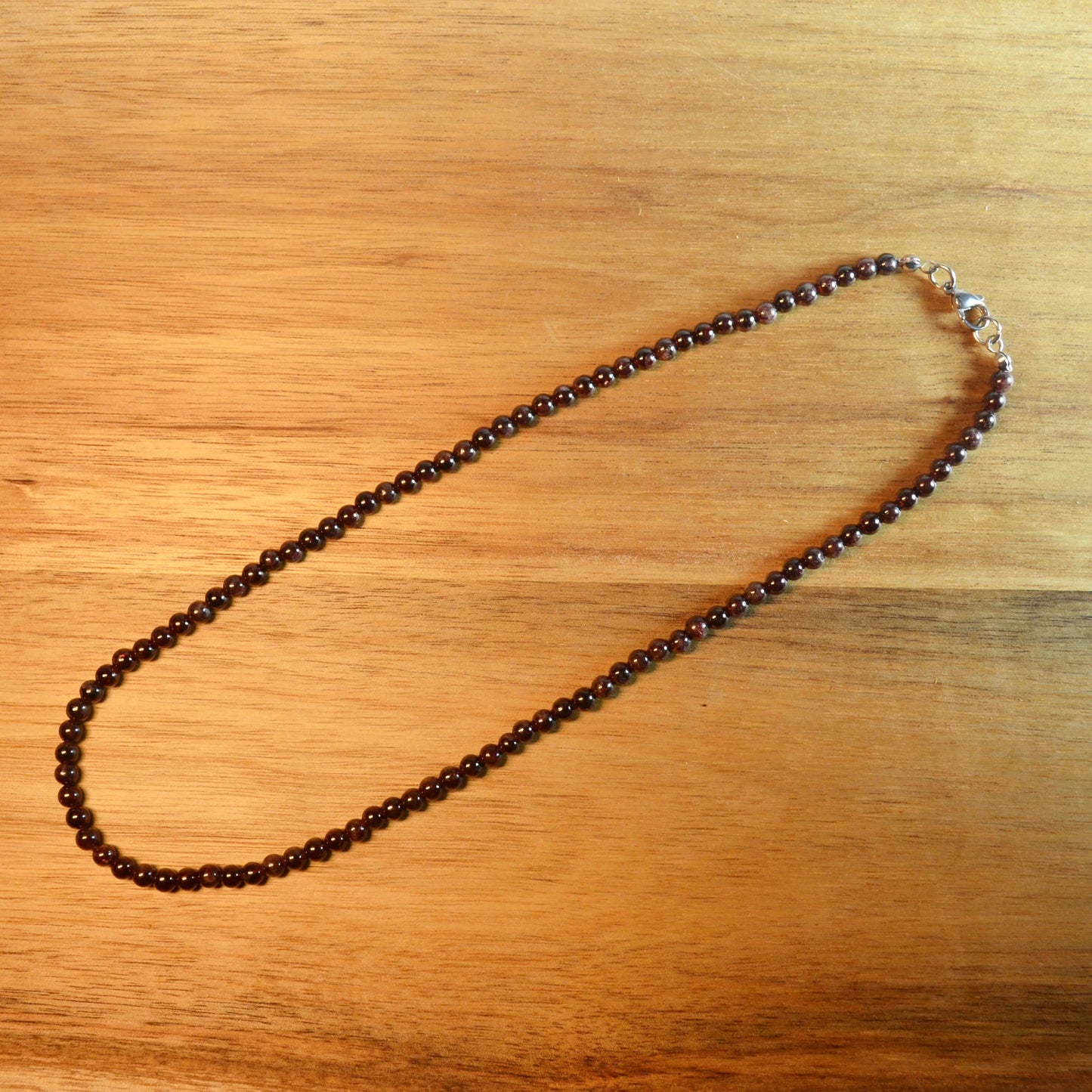 Granat Perlenkette aus 4mm Naturstein – Kristallschmuck mit Metallverschluss. Gesamtansicht.