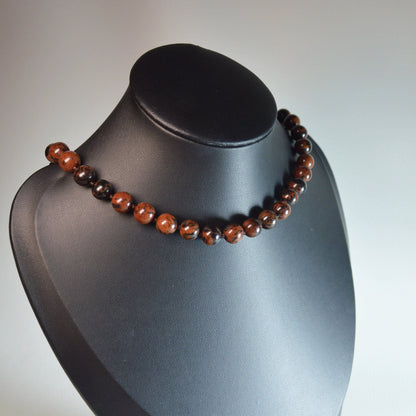 Handgemachte Mahagoni-Obsidian Halskette mit klaren Kristallperlen – hochwertiger Naturstein-Schmuck auf Büste.