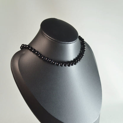 Handgemachte Onyxl Halskette mit schwarzen Kristallperlen – hochwertiger Naturstein-Schmuck auf Büste.