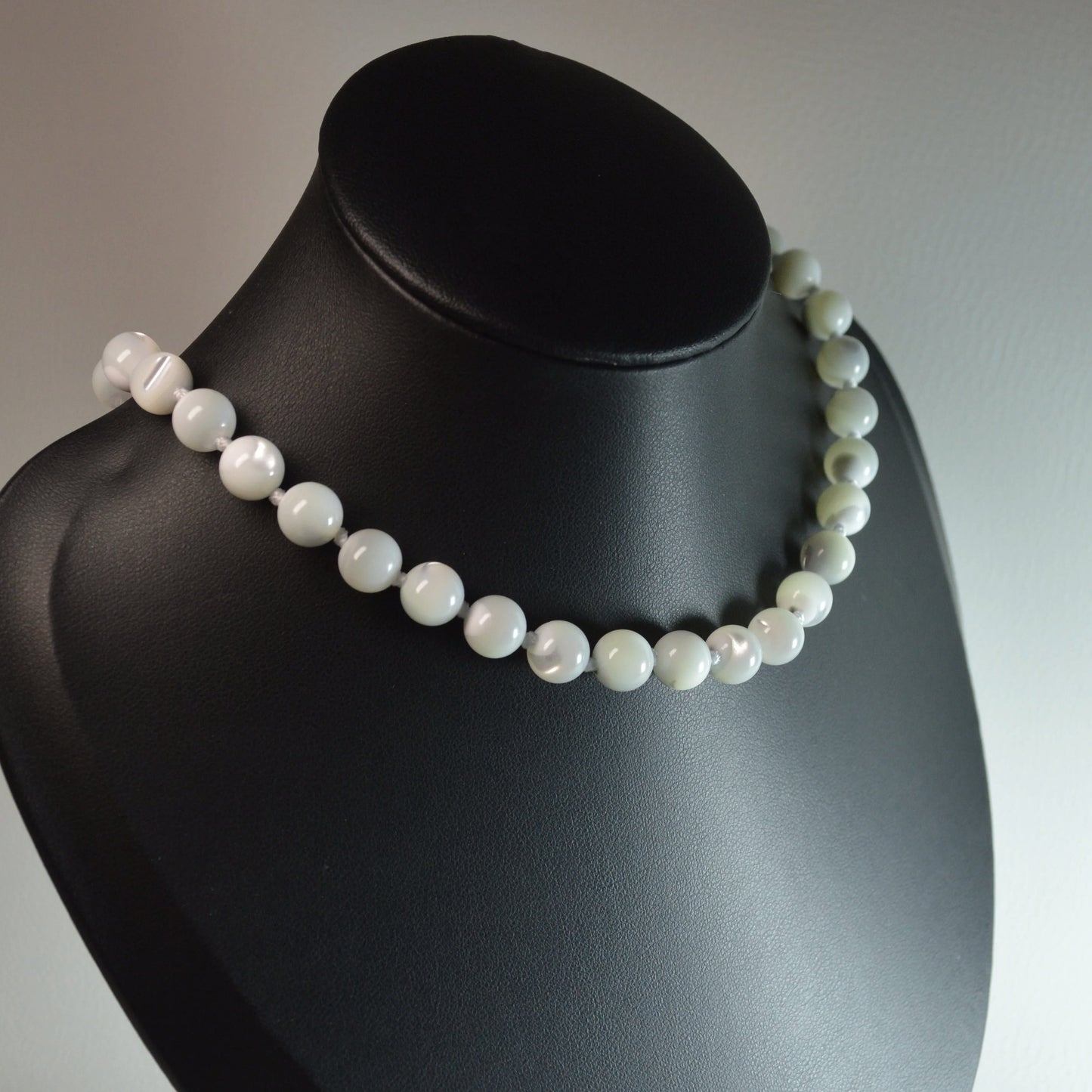 Handgemachte Perlmutt Halskette mit 8mm Perlen – hochwertiger Naturschmuck auf Büste.