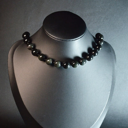 Handgemachte Regenbogenobsidian Halskette mit schillernden Kristallperlen – hochwertiger Naturstein-Schmuck auf Büste.