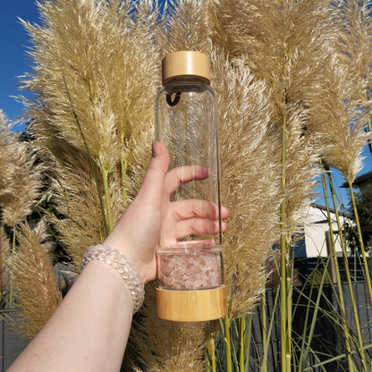 Kristall Trinflasche (Wasserflasche) aus Glas mit Rosenquarz Steinen.