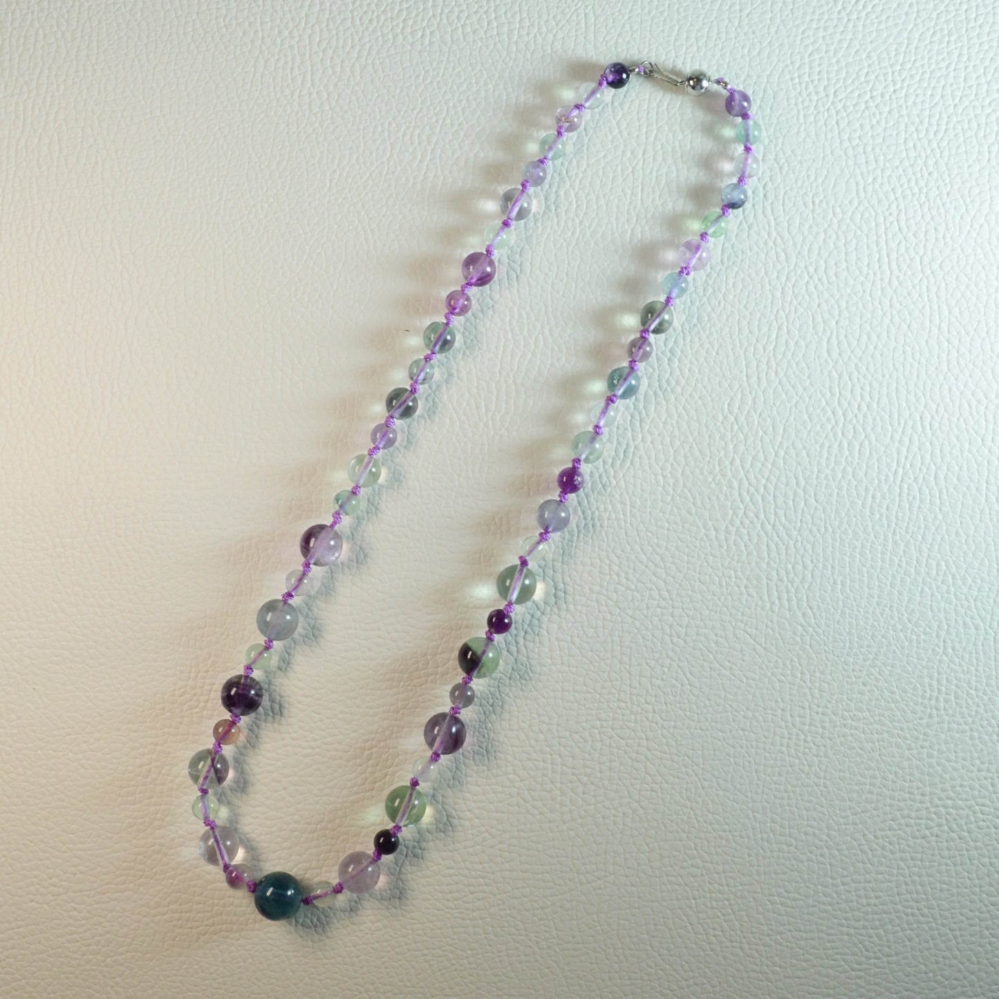 Regenbogenfluorit Perlenkette aus 5-10mm Naturstein – Kristallschmuck mit Metallkugelsteckverschluss. Gesamtansicht.