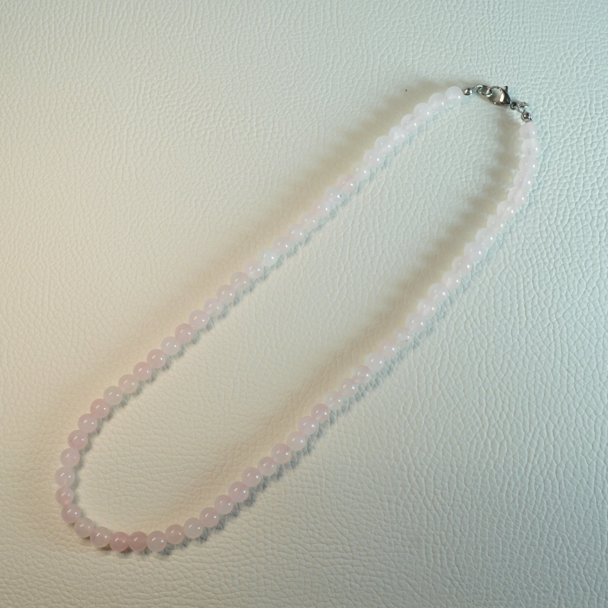 Rosenquarz Perlenkette aus 6mm Naturstein – Kristallschmuck mit Metallverschluss. Gesamtansicht.