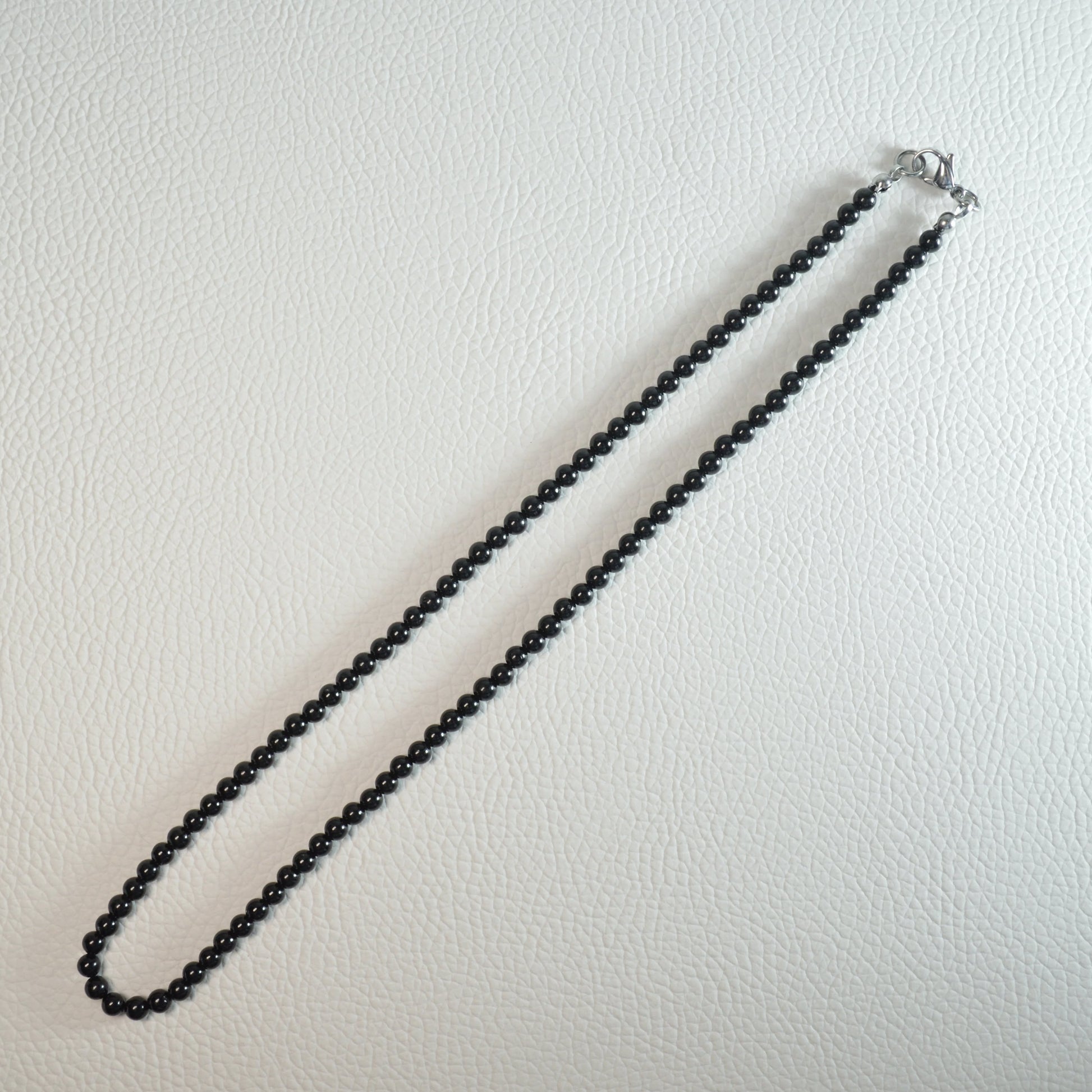 Schörl-Turmalin Perlenkette aus 4mm Naturstein – Kristallschmuck mit Metallverschluss. Gesamtansicht.