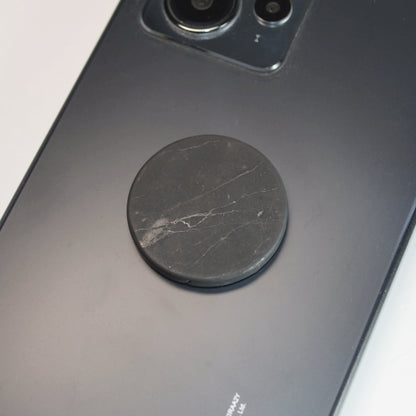 Detailaufnahme Schungit Handyplättchen – Naturstein mit Klebestreifen.