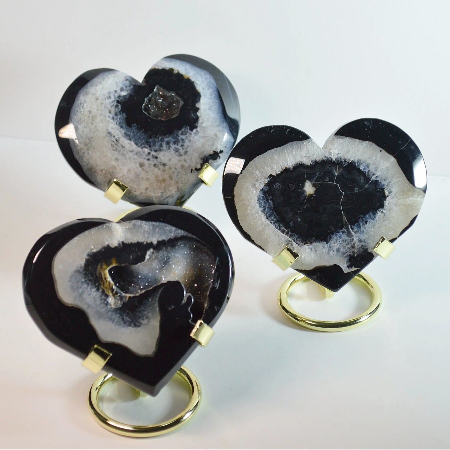 Schwarzes Achat Herz auf goldener Halterung – Vorderansicht, dekorativer Naturstein, Kristall-Dekoration.