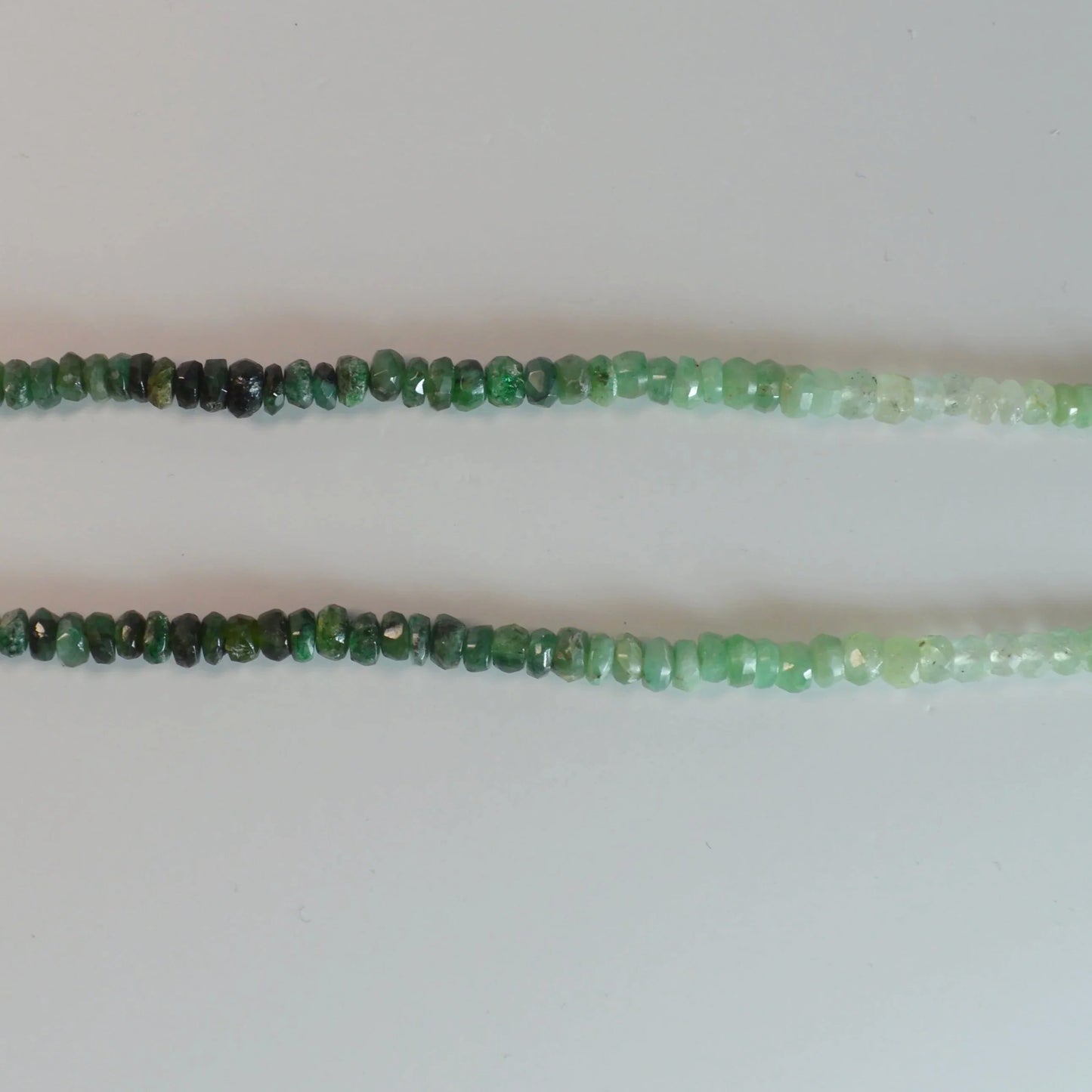 Facettierte Smaragd Halskette 45 cm – Nahaufnahme liegend, brillante Smaragd-Facetten erkennbar.