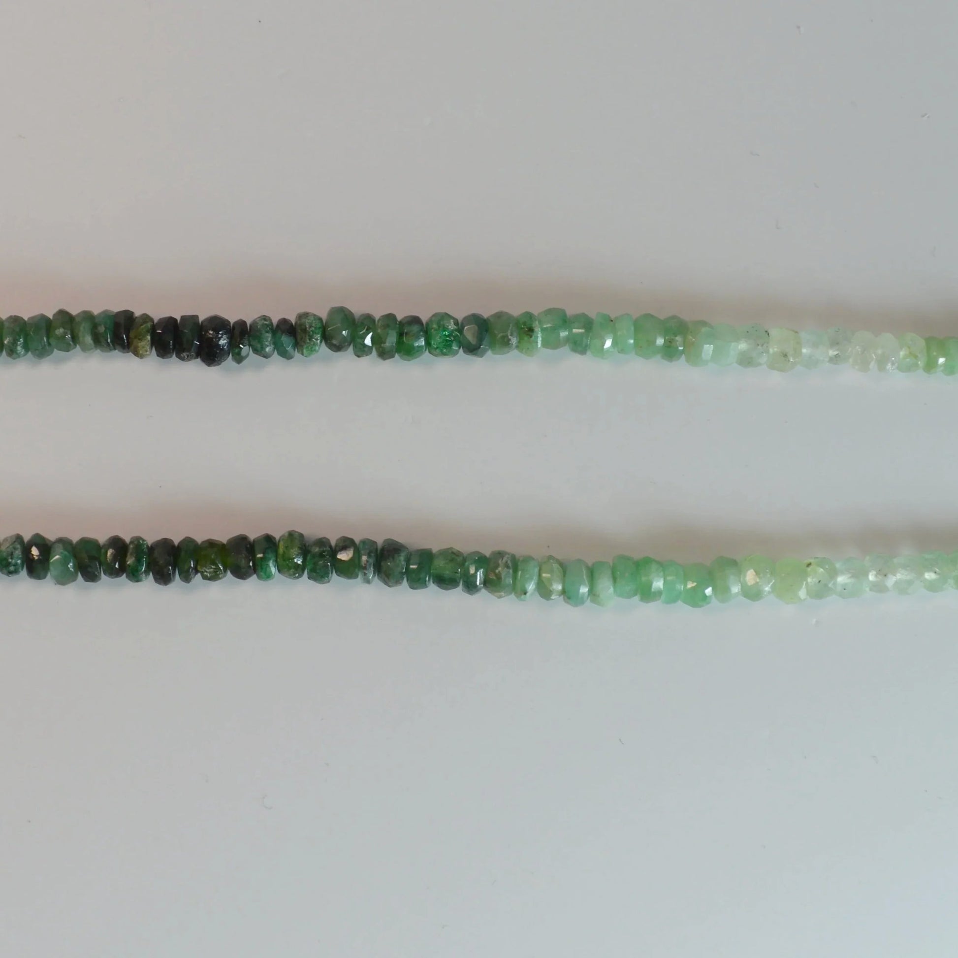 Facettierte Smaragd Halskette 45 cm – Nahaufnahme liegend, brillante Smaragd-Facetten erkennbar.