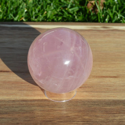 Sternrosenquarz Kugel, Vorderansicht, natürliche rosa Farbnuancen und sanfte Maserungen.