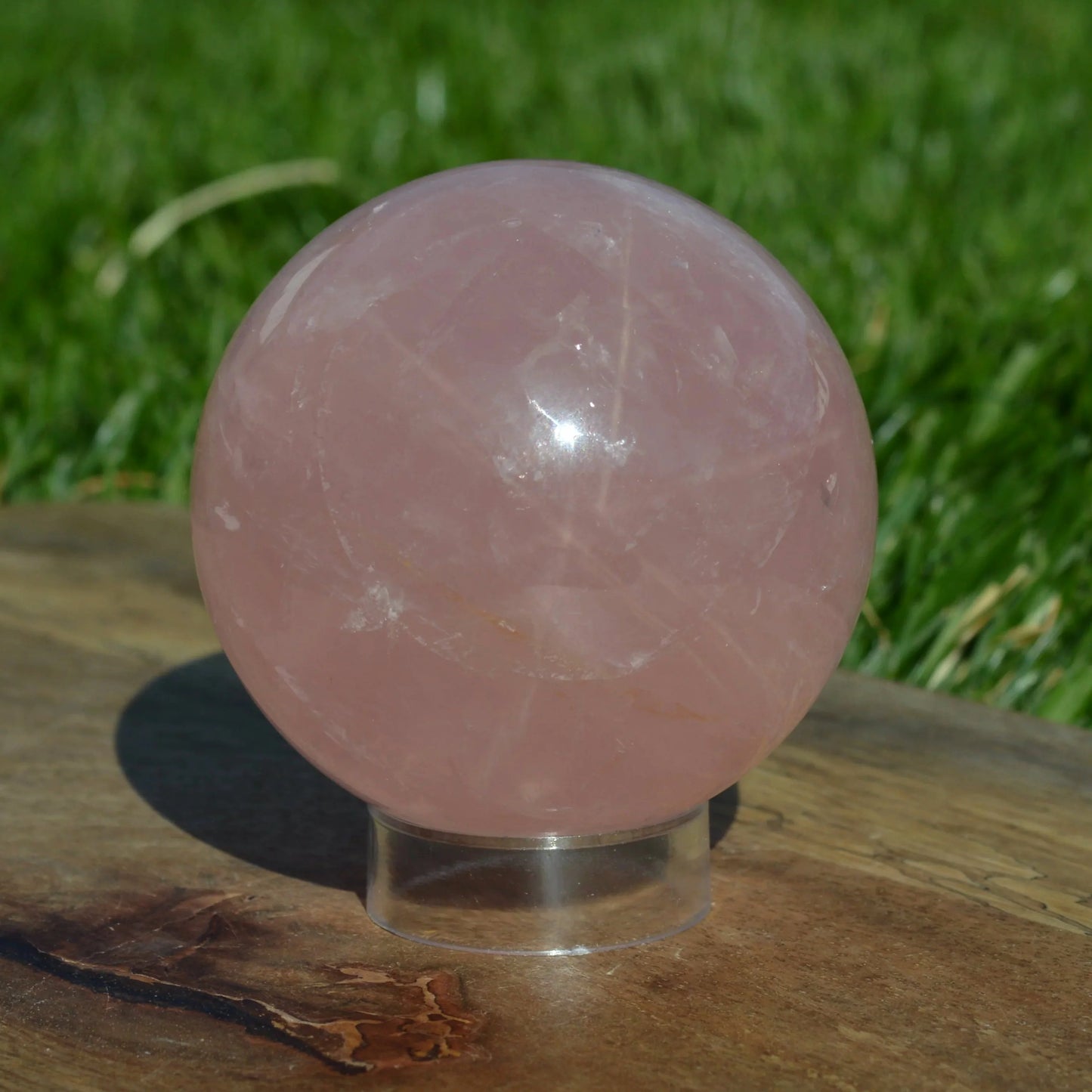 Detailaufnahme der Sternrosenquarz Kugel, mit besonderem Fokus auf die natürlichen Einschlüsse und das leuchtende Rosa.