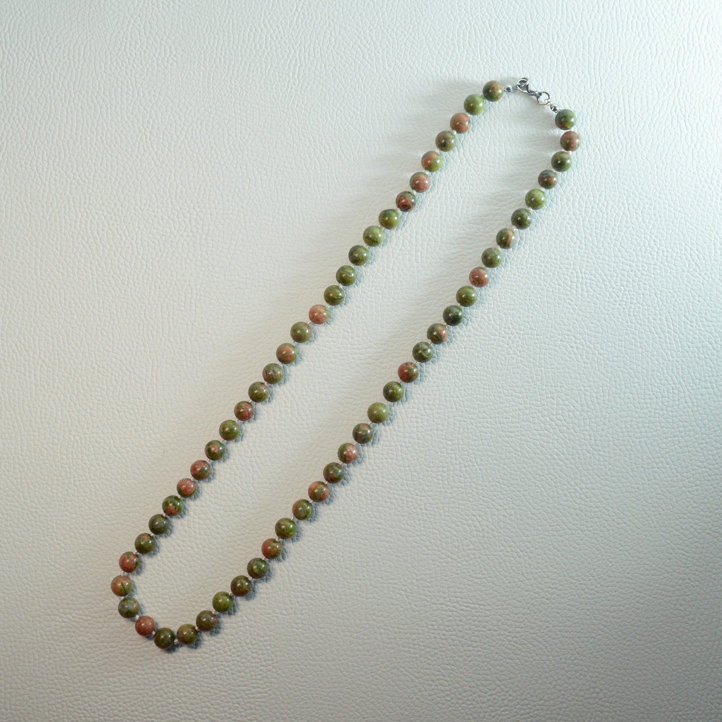 Unakit Perlenkette aus 8mm Naturstein – Kristallschmuck mit Metallverschluss. Gesamtansicht.